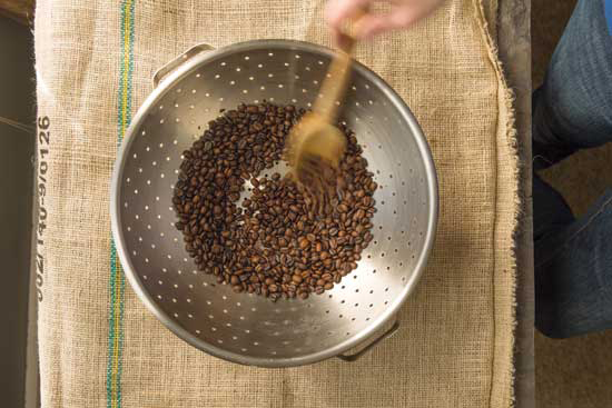 Cool your home-roasted coffee beans by stirring them rapidly in a colander for several minutes.
